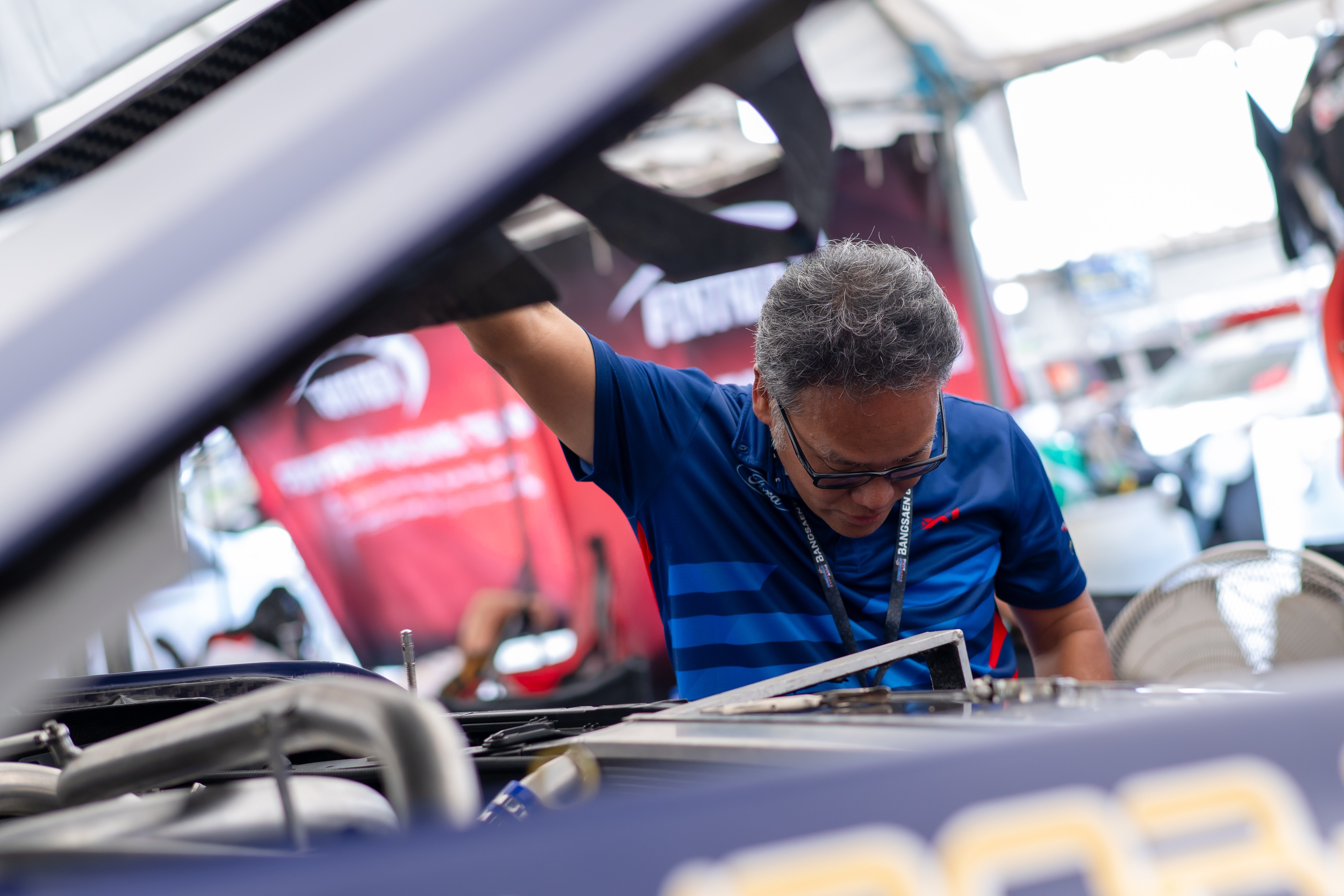  A member of the Ford Thailand Racing team inspects the highly modified engine bay of the Ford Ranger race truck.